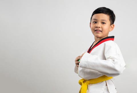Portrait Asian boy kid karate martial arts. Taekwondo uniform with yellow belt. Asian school boy isolated on white background